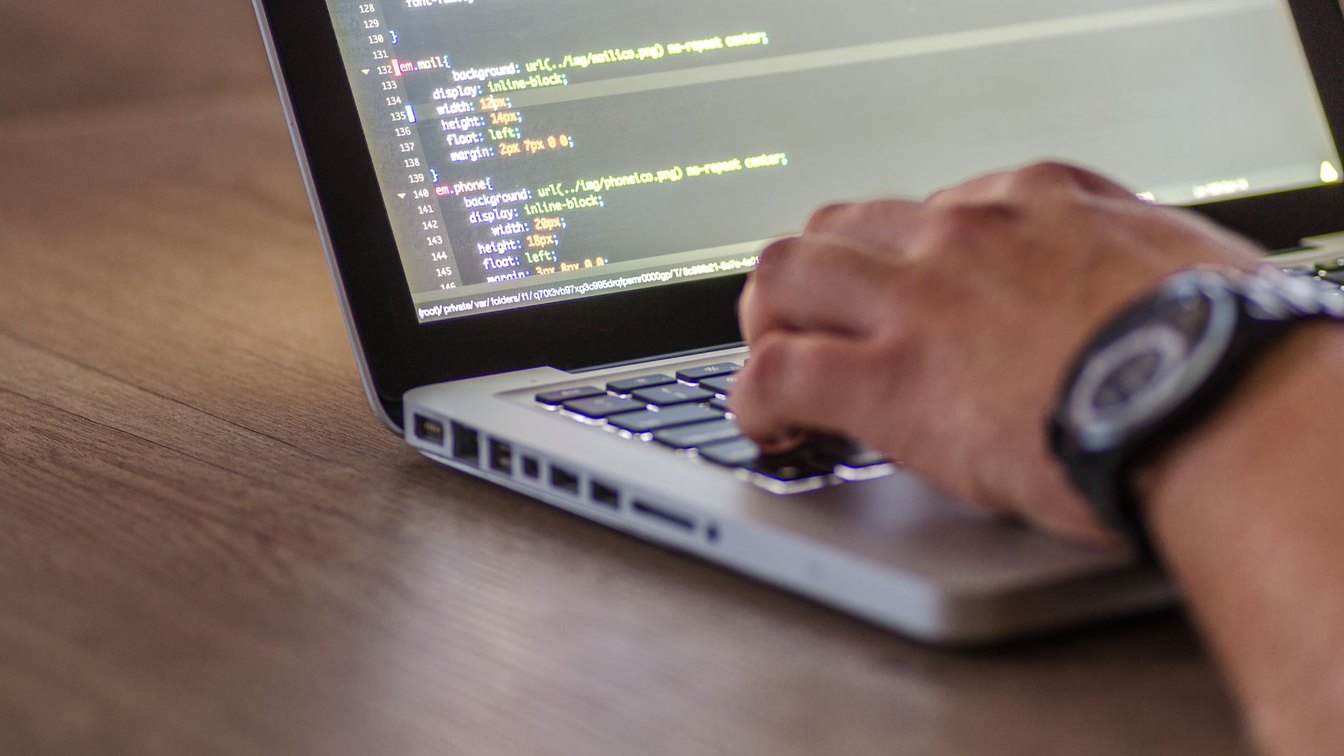 Close-up of a person's hand typing on a laptop keyboard