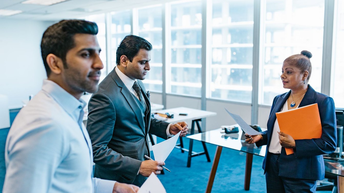 Business professionals discussing documents in a modern office environment